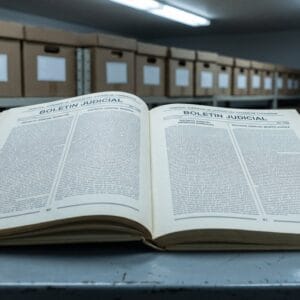 Ejemplar archivado del Boletín Judicial del Tribunal Superior de Justicia del Estado de Chihuahua, abierto sobre una mesa metálica de archivo, con dos columnas por plana encabezadas por distritos judiciales.