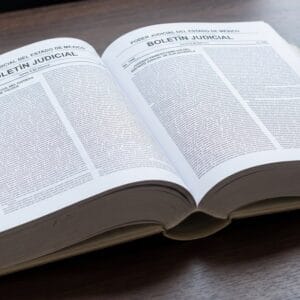 Tomo encuadernado del Boletín Judicial del Poder Judicial del Estado de México, abierto sobre un escritorio y mostrando las listas de acuerdos de dos juzgados